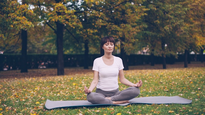 Woman meditating in a park — representing emotional regulation