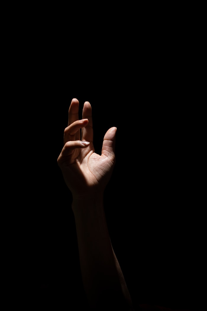 Hand reaching up from darkness — representing reaching for support